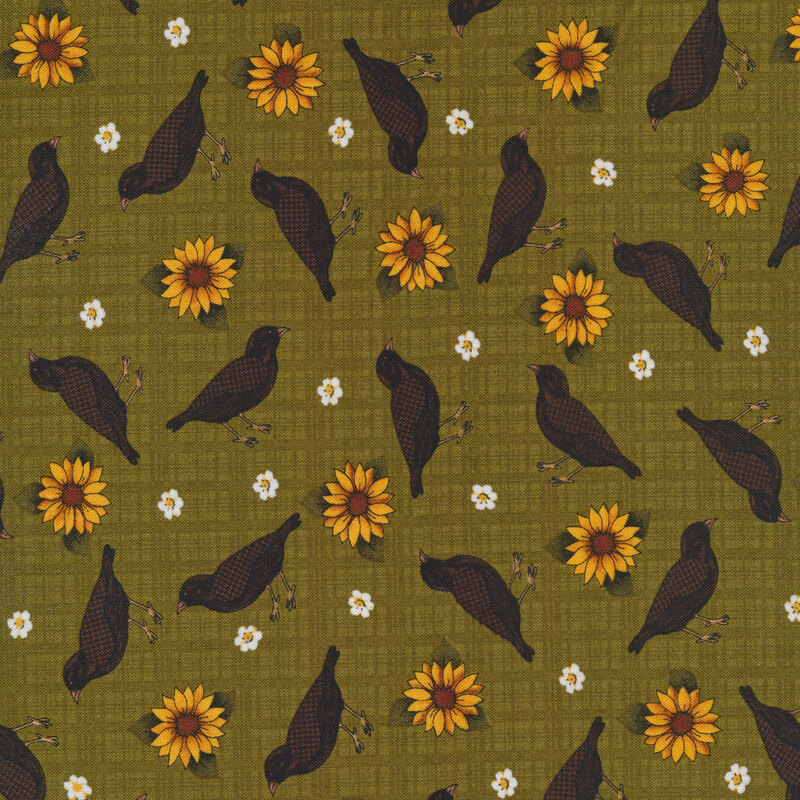 Sewing fabric with small flowers, black birds, and sunflowers all over a green background