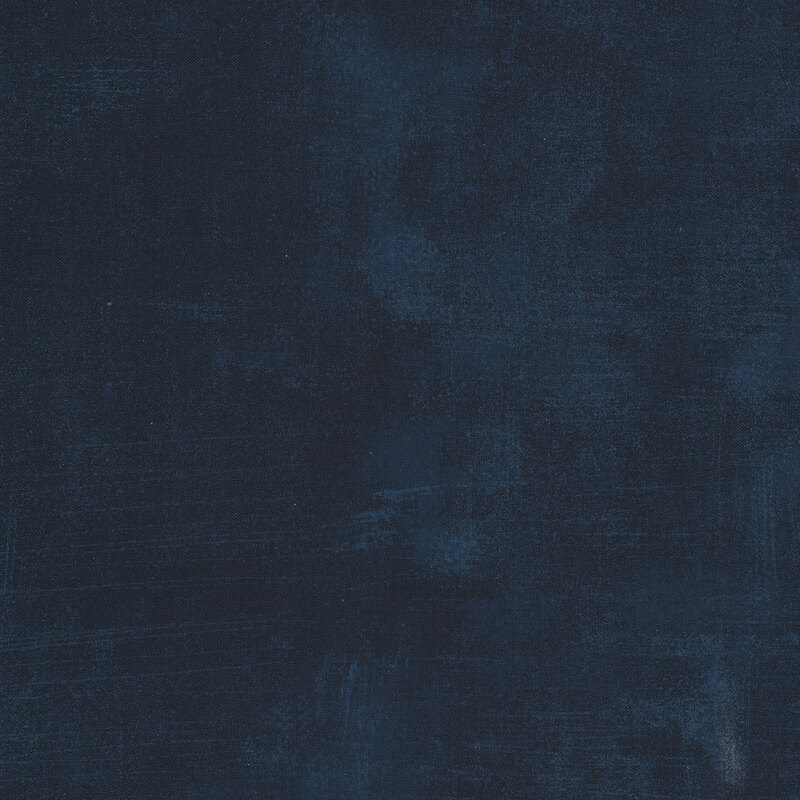 A dark navy fabric with bits of lighter blue grunge texturing