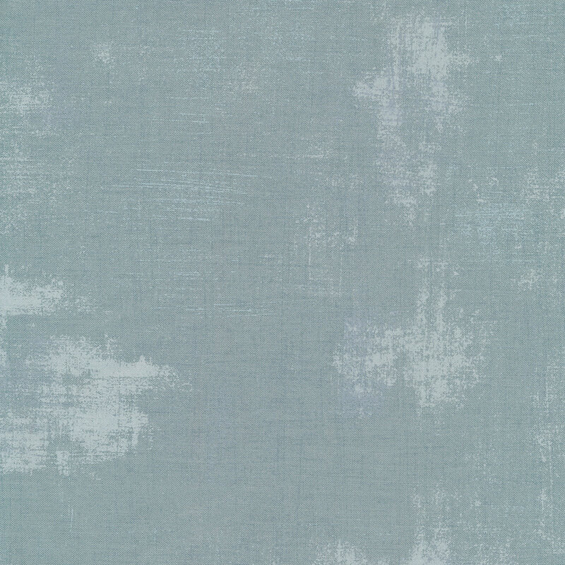 A pale blue grey fabric with bits of lighter blue grunge texturing