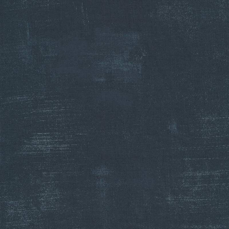 A deep blue fabric with bits of lighter blue grunge texturing