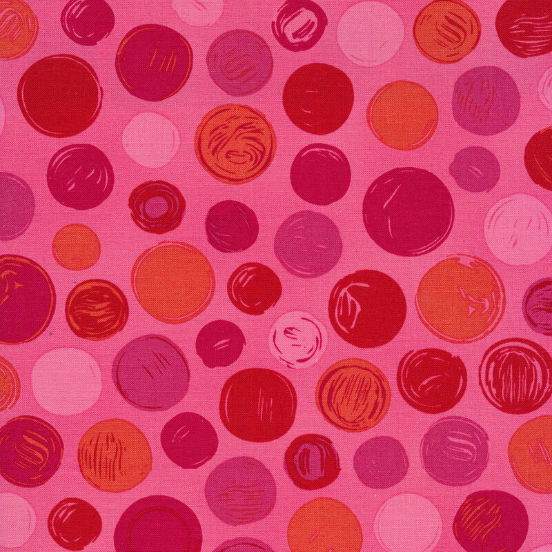 Pink fabric with red, purple, and pink polka dots of varying sizes