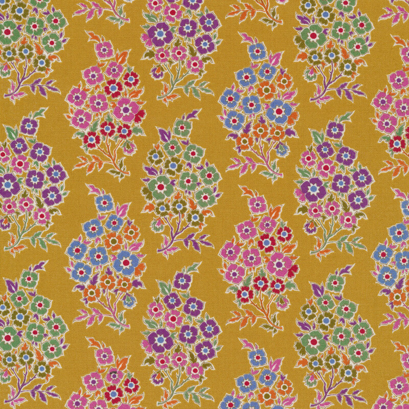 Mustard colored fabric with bunches of purple, blue, green, pink and orange flowers