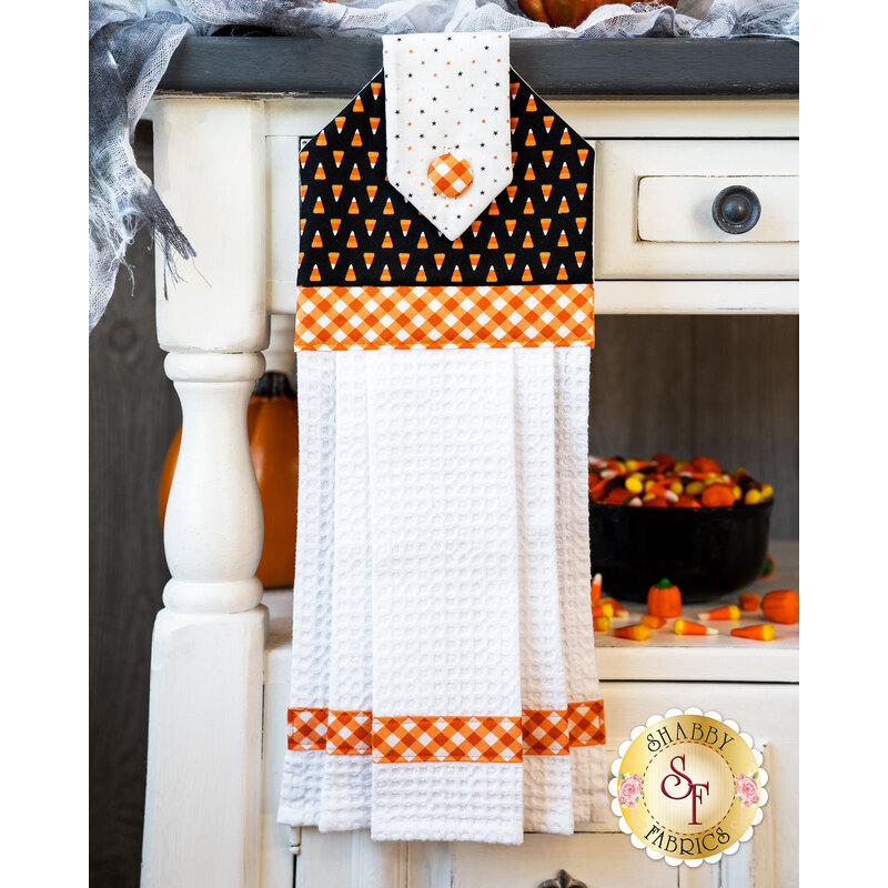 Black, orange, and white hanging towel with candy corn print and orange gingham.