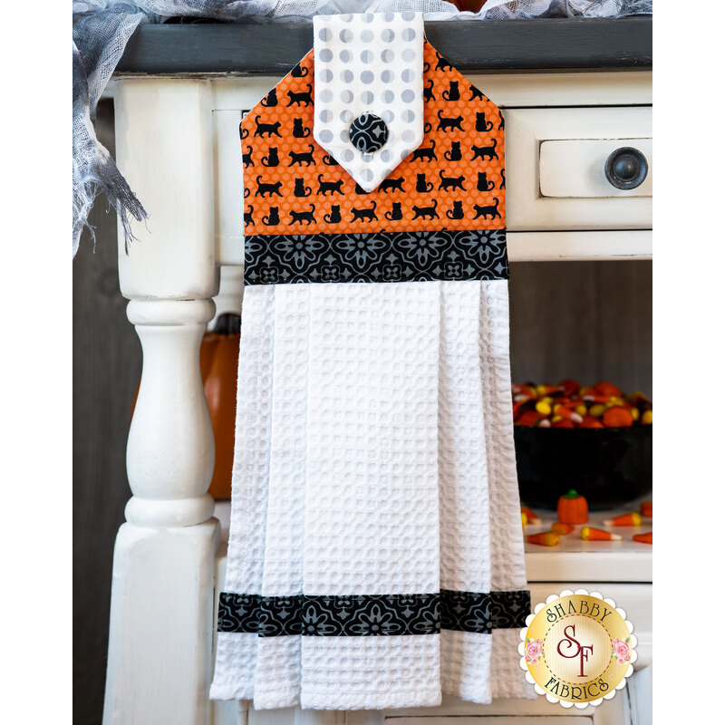 Black, orange, and white hanging towel with black cat print and black accents.