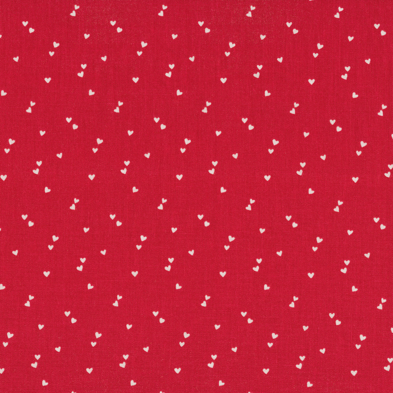 Bright red fabric with pairs of tiny white hearts scattered all over