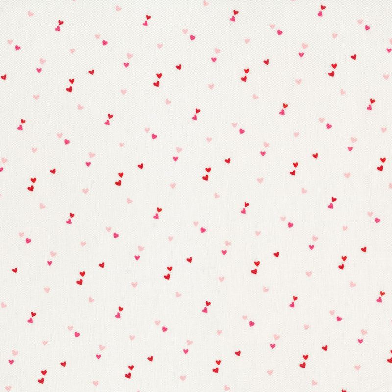 white fabric with pairs of tiny pink and red hearts scattered all over