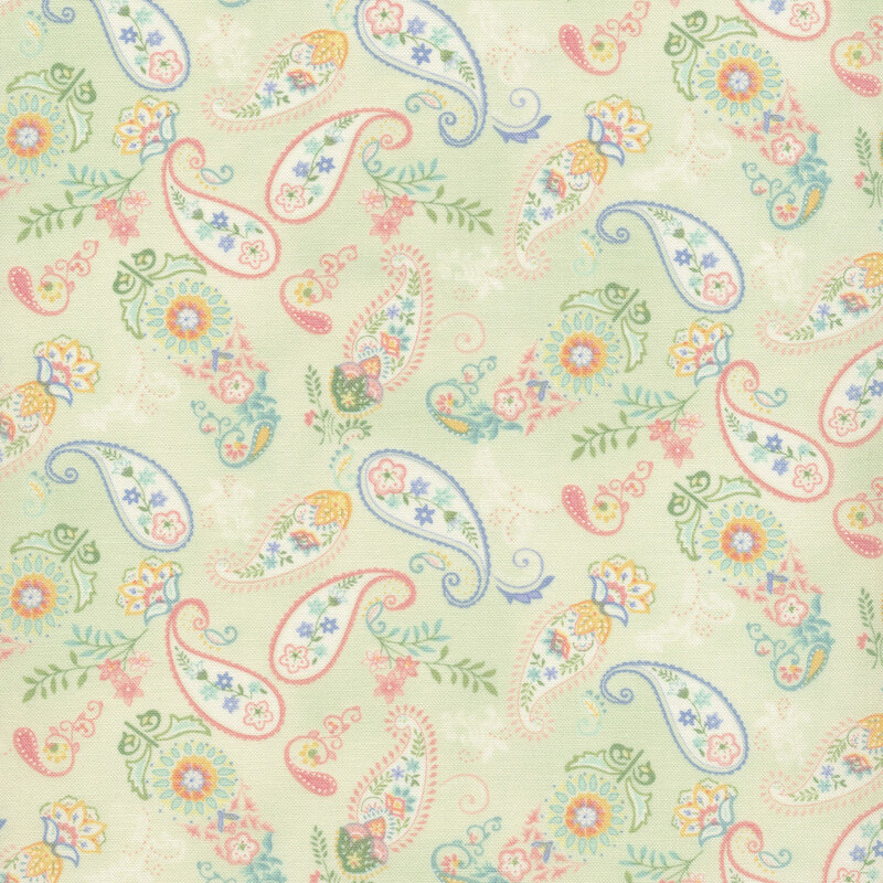 fabric with blue, green and pink florals and paisley print on a light green background