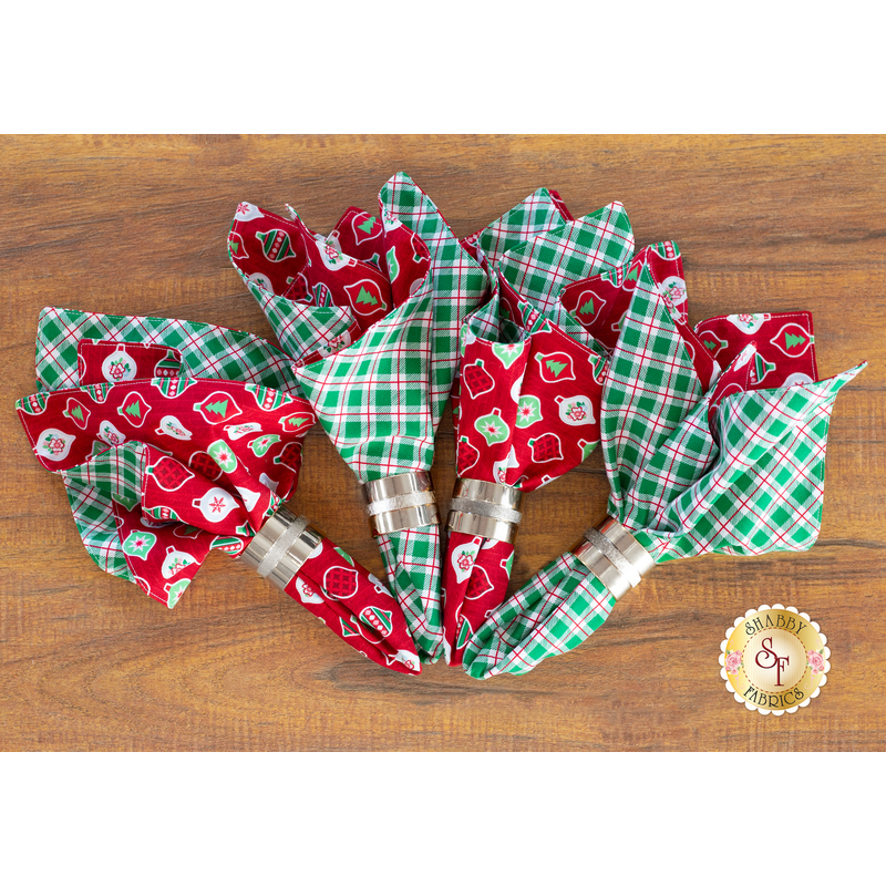 Cluster of 4 red and green napkins fanned together on a wood background