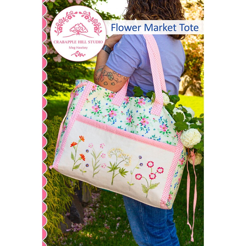 front of Flower Market Tote pattern showing a woman holding the finished tote filled with flowers over one shoulder, standing outside