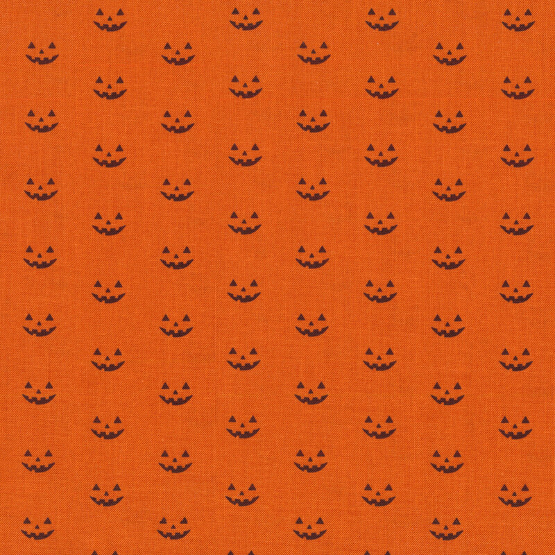 Orange fabric with rows of staggered black jack o'lantern faces