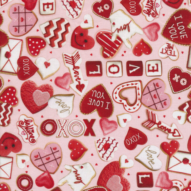light pink fabric with heart shapes and valentine's day themed cookies frosted with red and pink frosting tossed all over