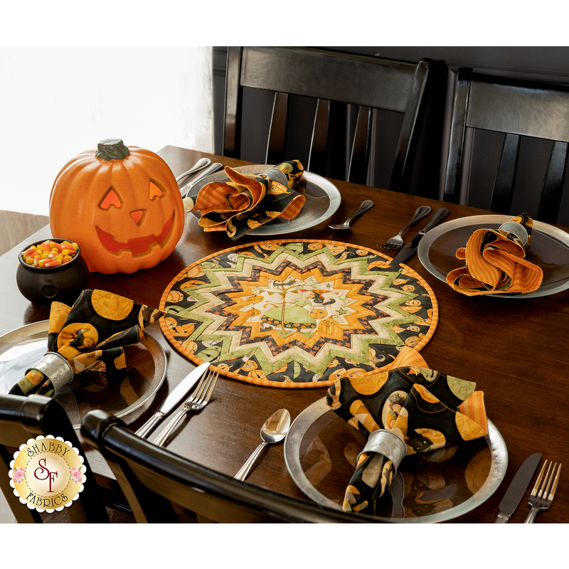 Folded star table topper with whimsical halloween prints in orange, cream, and green.