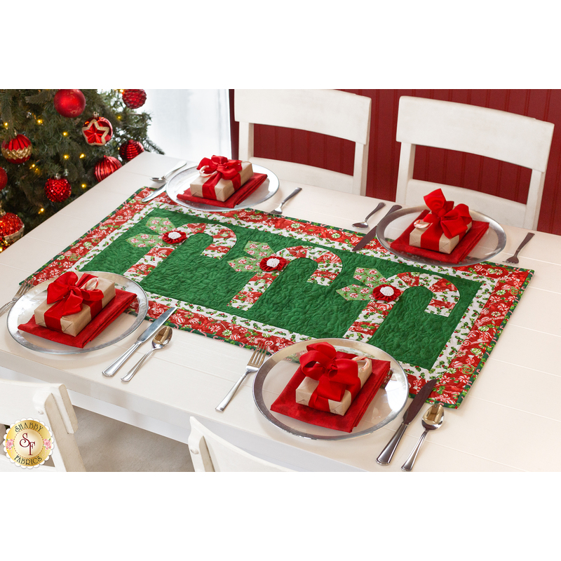 angled image of candy cane table runner showing red and white candy canes on a green background with a red border