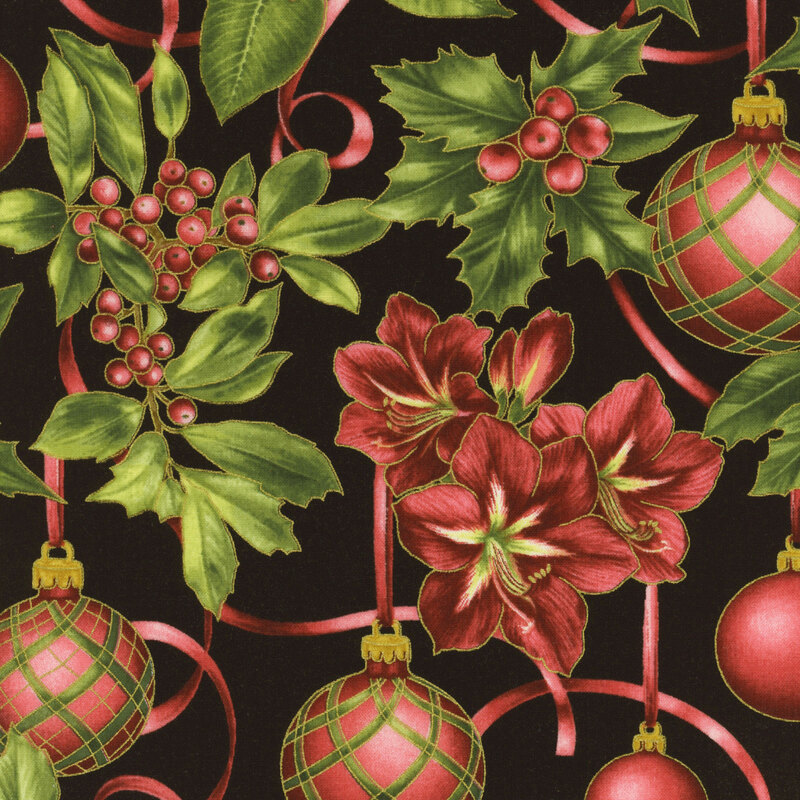 Green holly and berries, red poinsettias, and Christmas ornaments on a black fabric background