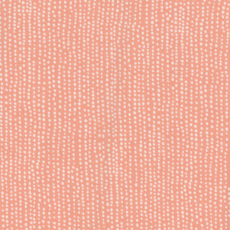 Pink fabric with irregular lines of small white dots close together