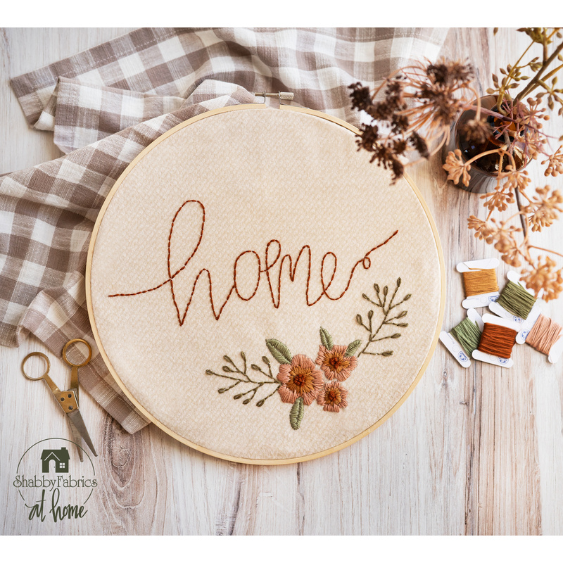 Embroidery hoop with hand embroidery featuring florals and the word home.