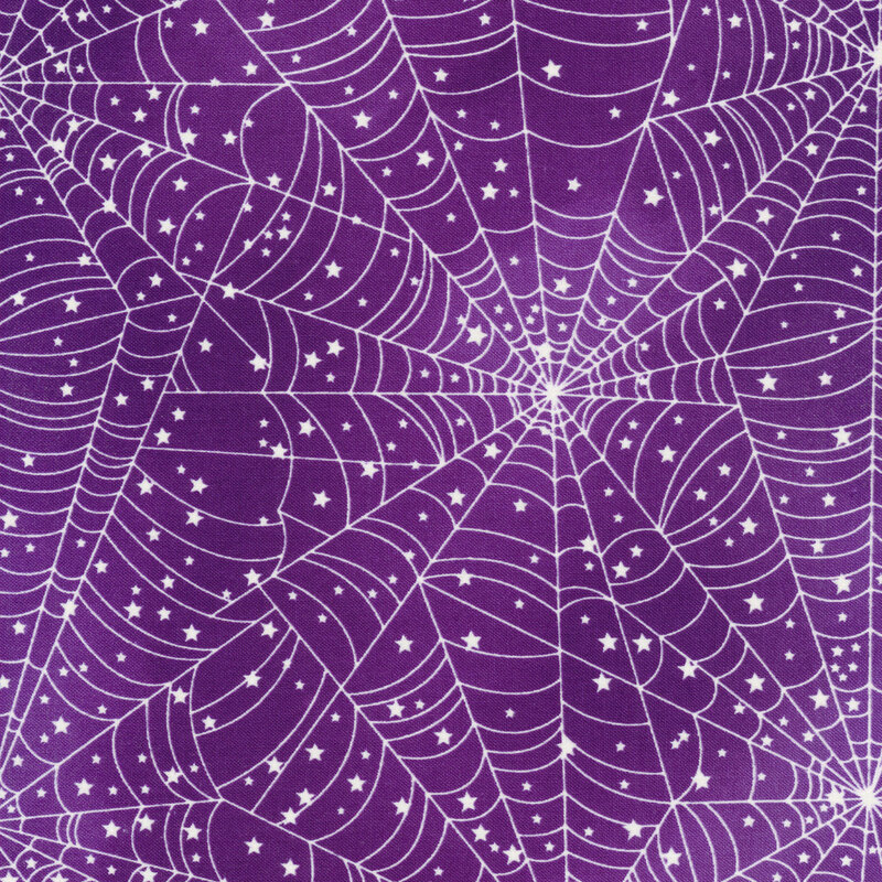 scan of fabric with glowing white spider web pattern and tossed ditzy stars on a purple background