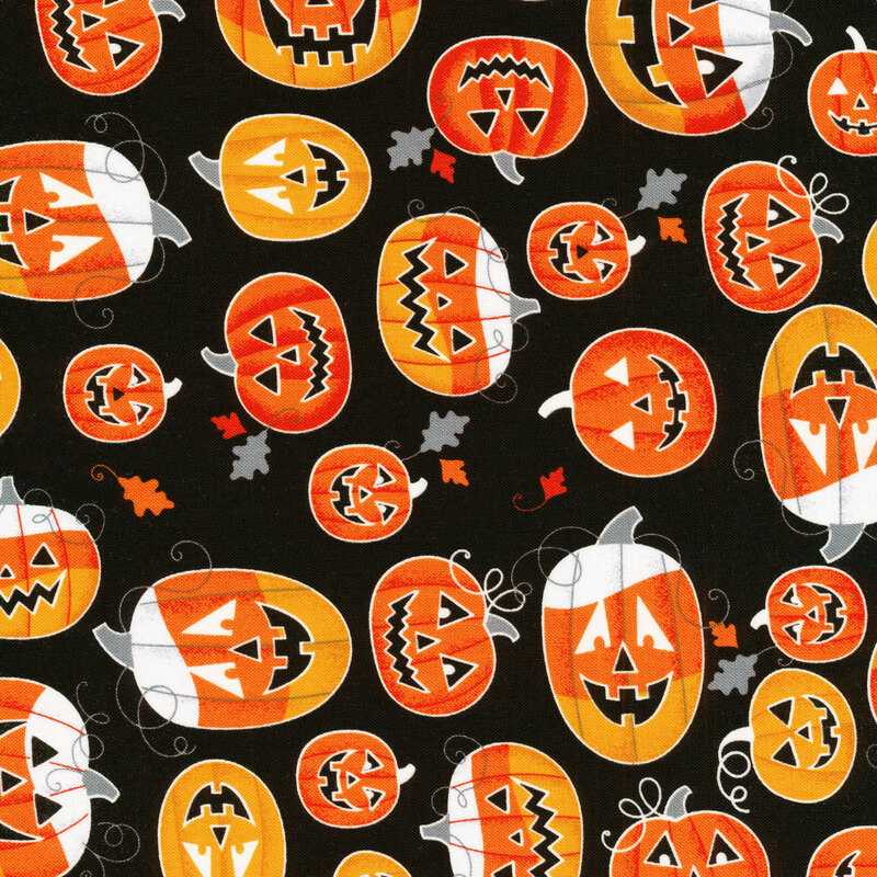 scan of fabric with bright orange and white jack-o-lanterns on a black background