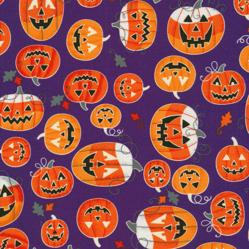 scan of fabric with bright orange and white jack-o-lanterns on a purple background