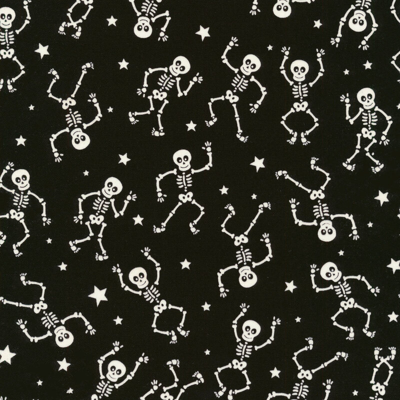 scan of fabric with white dancing skeletons and tossed stars on a black background
