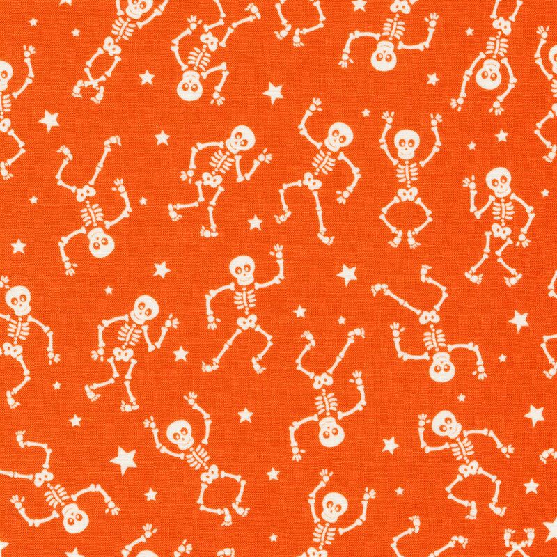 scan of fabric with white dancing skeletons and tossed stars on an orange background
