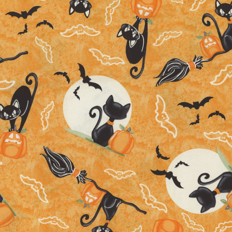 Orange fabric with black cats riding on brooms and sitting next to jack-o-lanterns