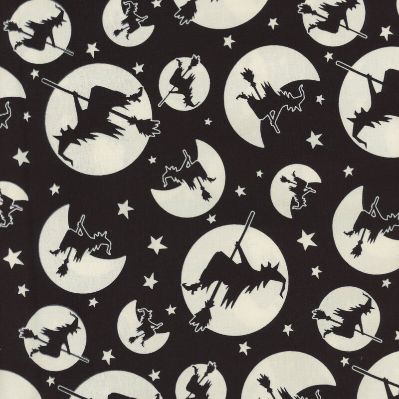 Black fabric with dark outlines of witches flying on brooms in front of solid white moons