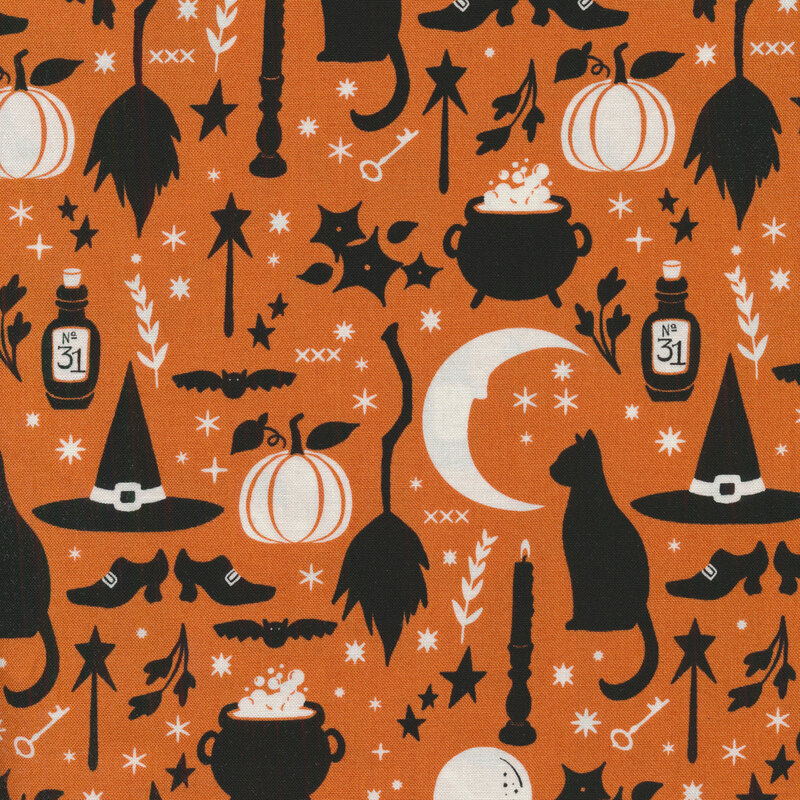 Orange fabric with silhouettes in black and white of Halloween motifs like cats, candlesticks, brooms, a crescent moon, crystal ball, etc.