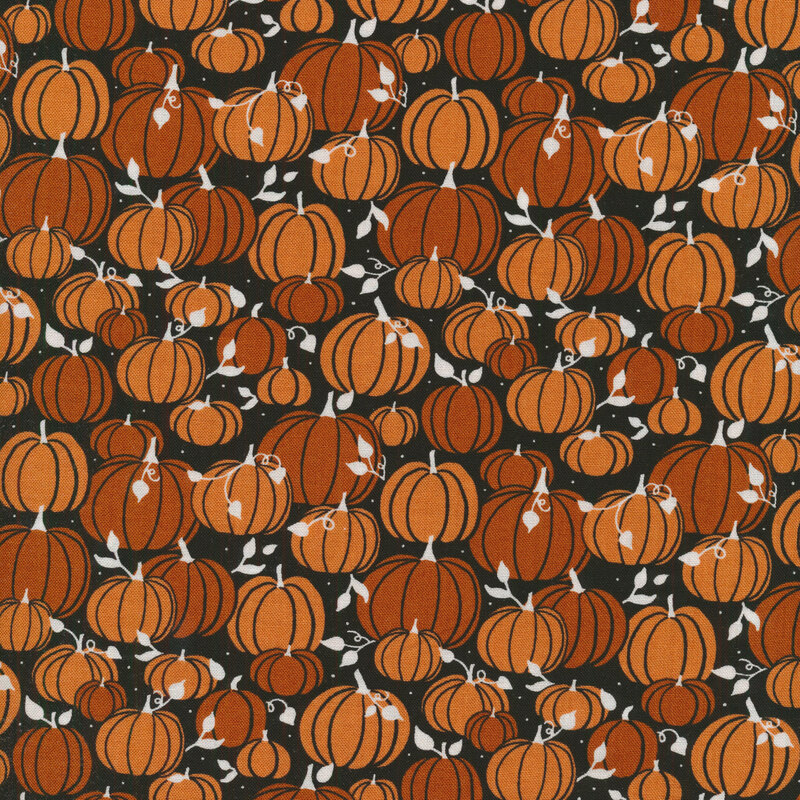 Black fabric covered in orange pumpkins and white leaves and vines