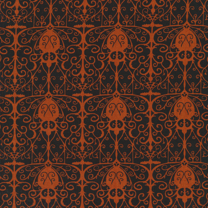 Black fabric with an orange repeated wrought iron gate design silhouetted in the foreground