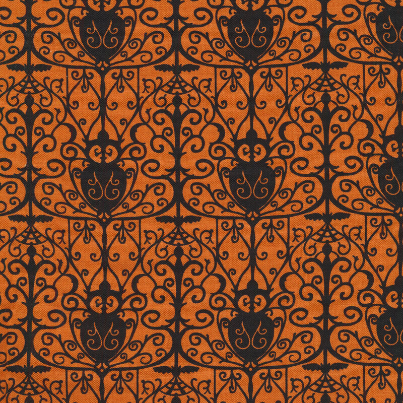 Orange fabric with a black repeated wrought iron gate design silhouetted in the foreground