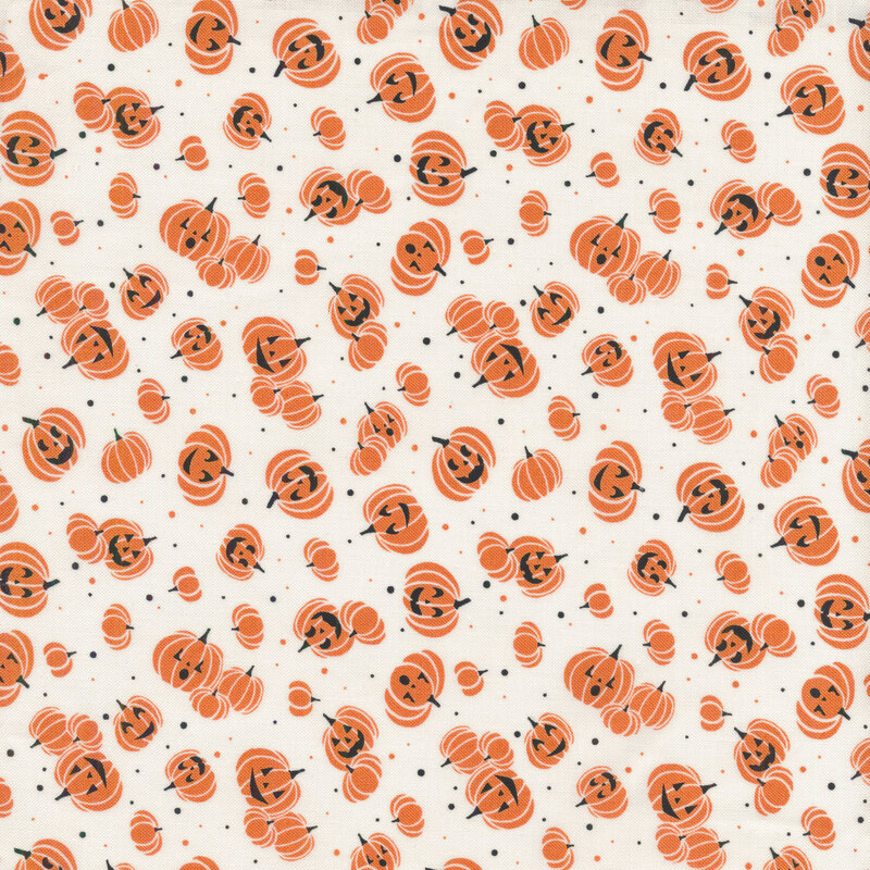 White fabric with tossed orange jack o lanterns and small orange and black dots