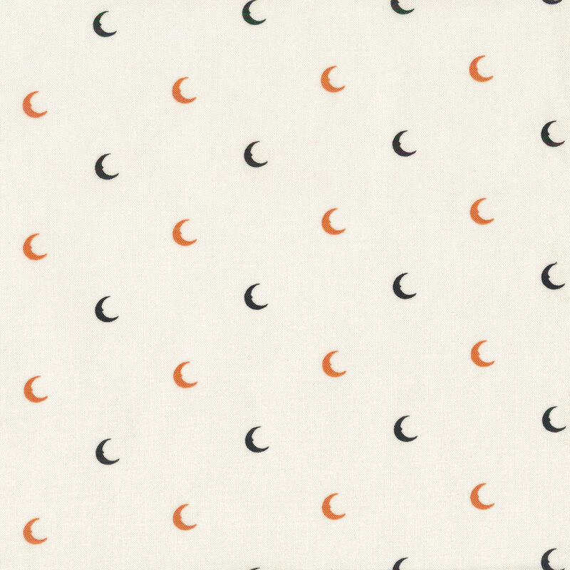 White fabric with orange and black crescent moons evenly spaced all over