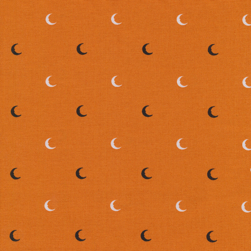 orange fabric with black and white crescent moons evenly spaced all over