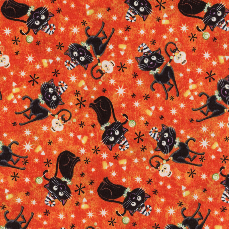 Orange fabric with cartoon black cats wearing black and white striped hats holding skull buckets of candy and lollipops with their tails with candy corn and stars all over