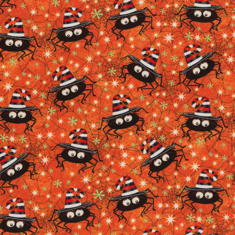 Orange fabric with spiderwebs and cartoon spiders wearing striped witch hats with green and white stars all over