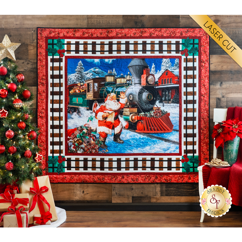 Panel quilt featuring Santa waving next to a train in a snowy village and train track border.