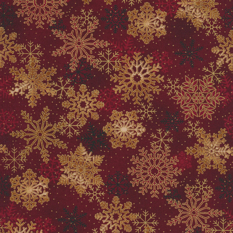 Dark red mottled fabric with large gold metallic snowflakes all over
