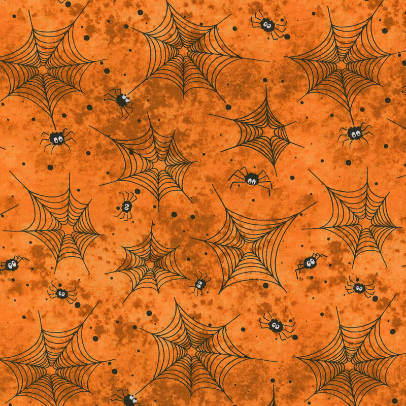 Orange fabric with black spider webs, dots, and spiders all over
