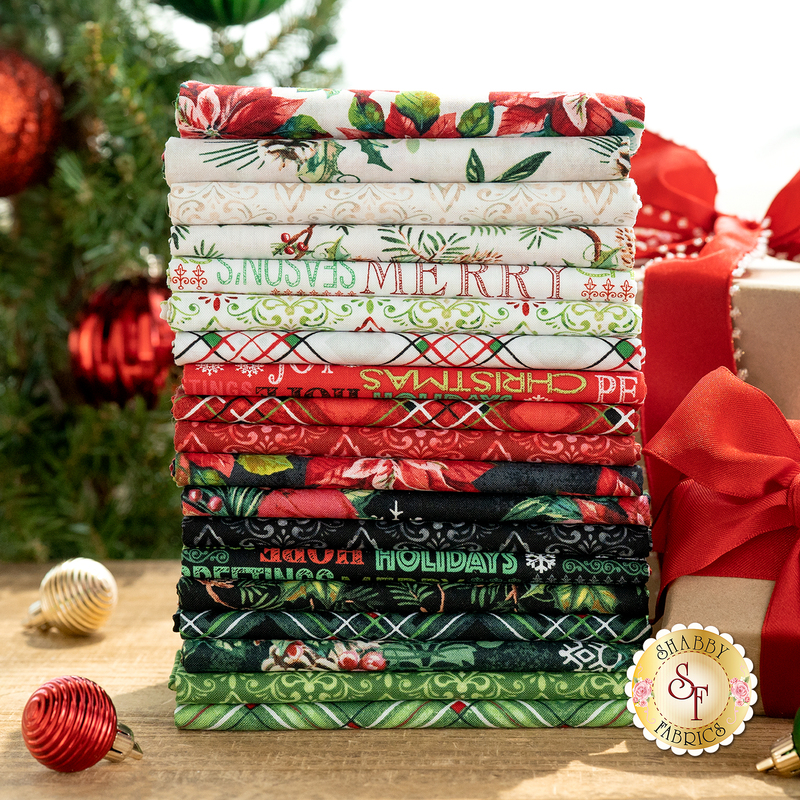 A photographed stack of red, black, and white Christmas fabrics in the Holiday Greetings 19 Half Yard Set