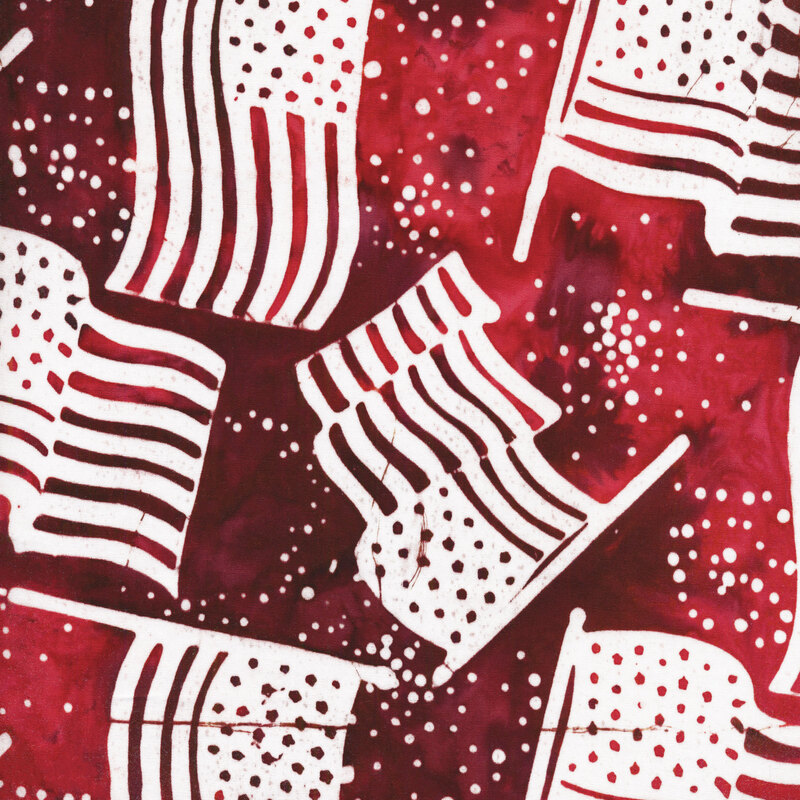 red mottled fabric with white American flags tossed in the foreground