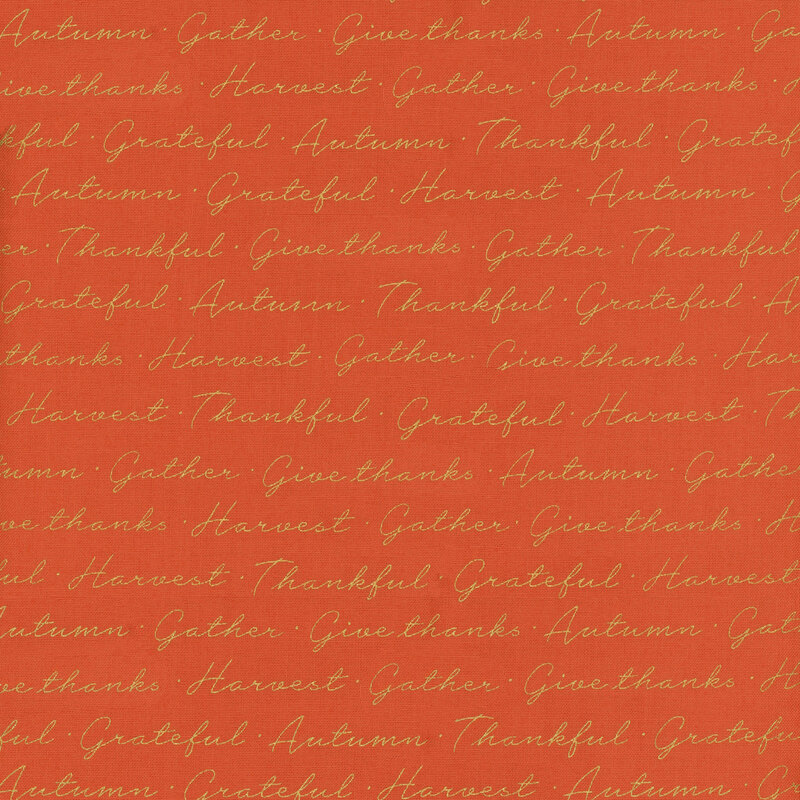 fabric featuring bright orange background with gold metallic cursive writing