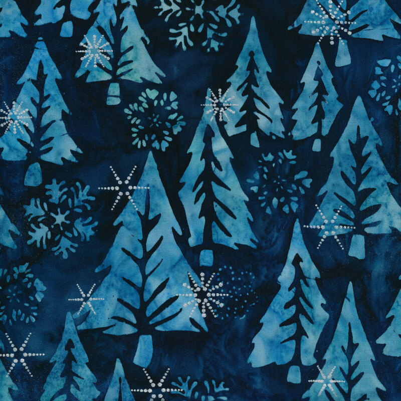 Dark blue marbled batik fabric with large tonal pine trees and snowflakes with silver metallic accents