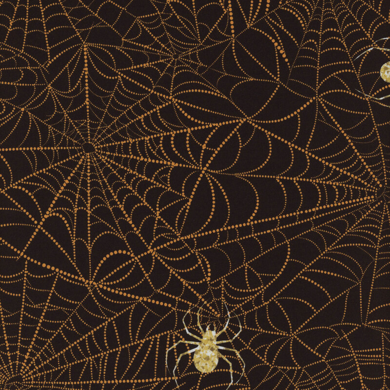 fabric featuring orange spiderwebs on a brown background with gold spiders 