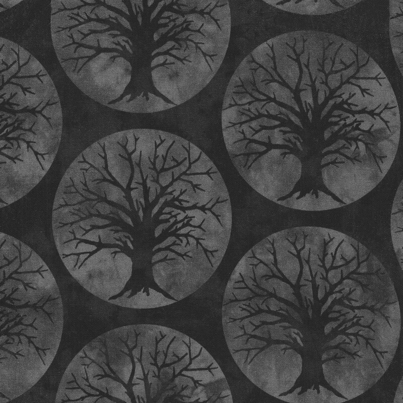 Black fabric with large gray circular moons and silhouettes of scary trees on a dark gray background