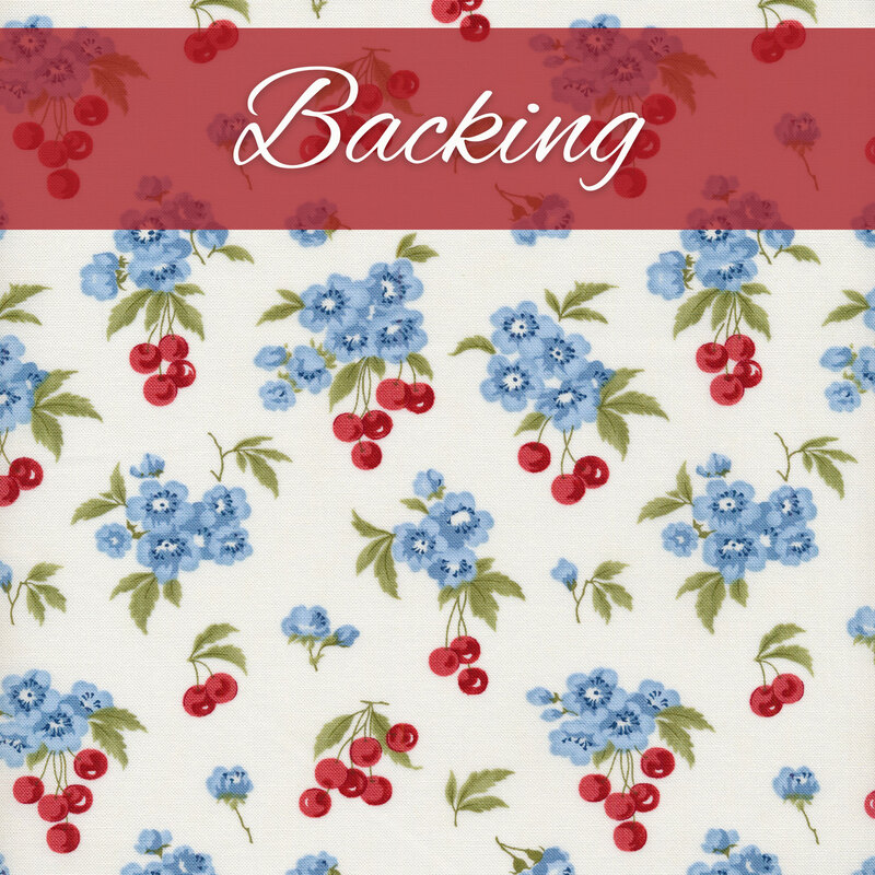 White fabric with clusters of blue flowers and red cherries with green leaves with a red banner and the word 