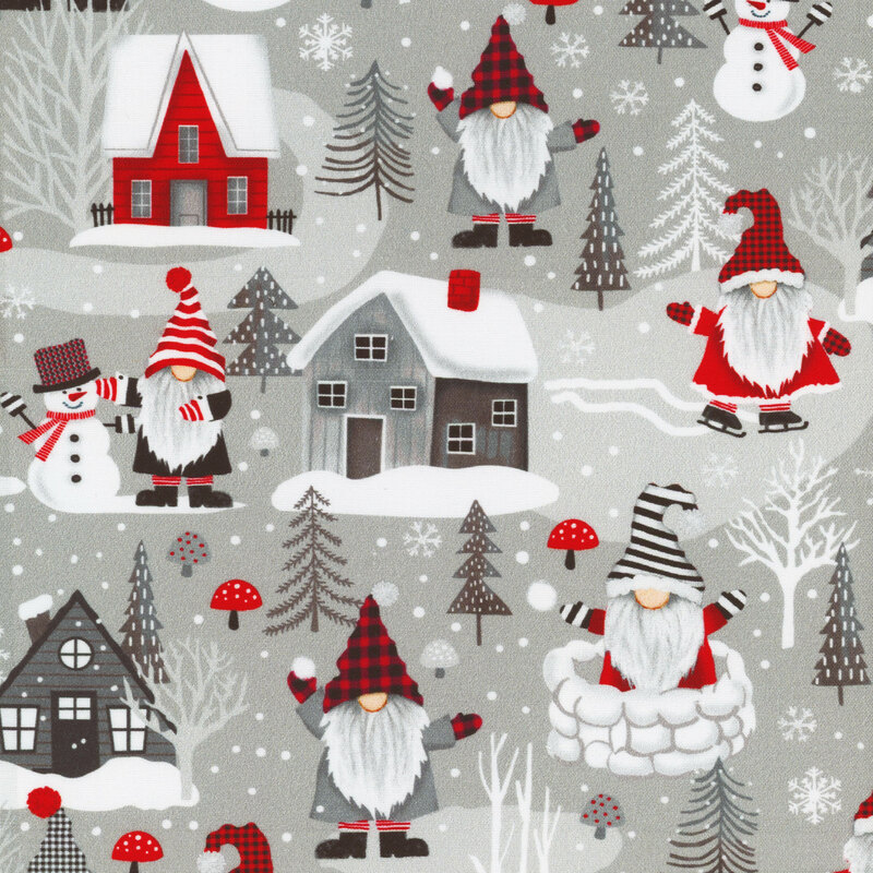 fabric featuring ice skating gnomes and snowmen between snow covered houses on a gray background