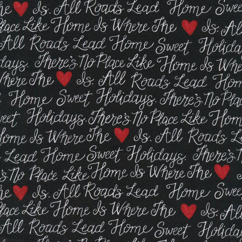 fabric with white cursive writing of christmas phrases with red hearts on a solid black background