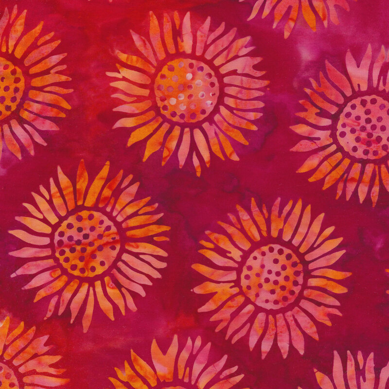 bright pink and purple mottled fabric with round sunflowers spaced evenly apart with a pink and orange mottled watercolor look