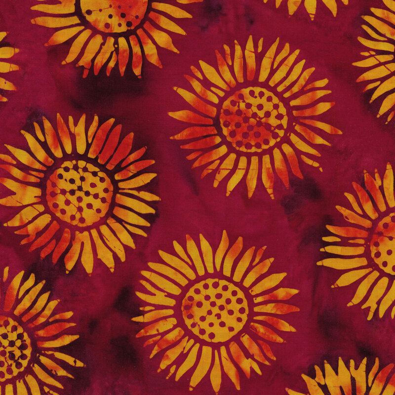 bright pink and purple mottled fabric with round sunflowers spaced evenly apart with a red and yellow mottled watercolor look
